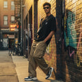 CODE92 oversized black organic cotton t-shirt with spider graphic worn by a man in cargo pants in an urban alley