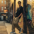 CODE92 oversized black organic cotton t-shirt with spider graphic worn by a man in cargo pants in an urban alley
