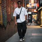 CODE92 oversized white organic cotton t-shirt with spider graphic worn by a man in an urban alleyway