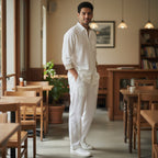 CODE92 white linen shirt with brown collar detail worn by a man in a casual cafe setting